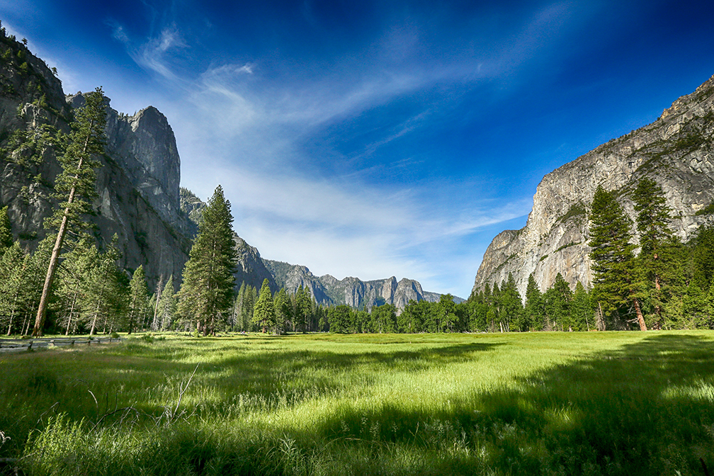 Mountain valley with forested slopes and cloudy sky